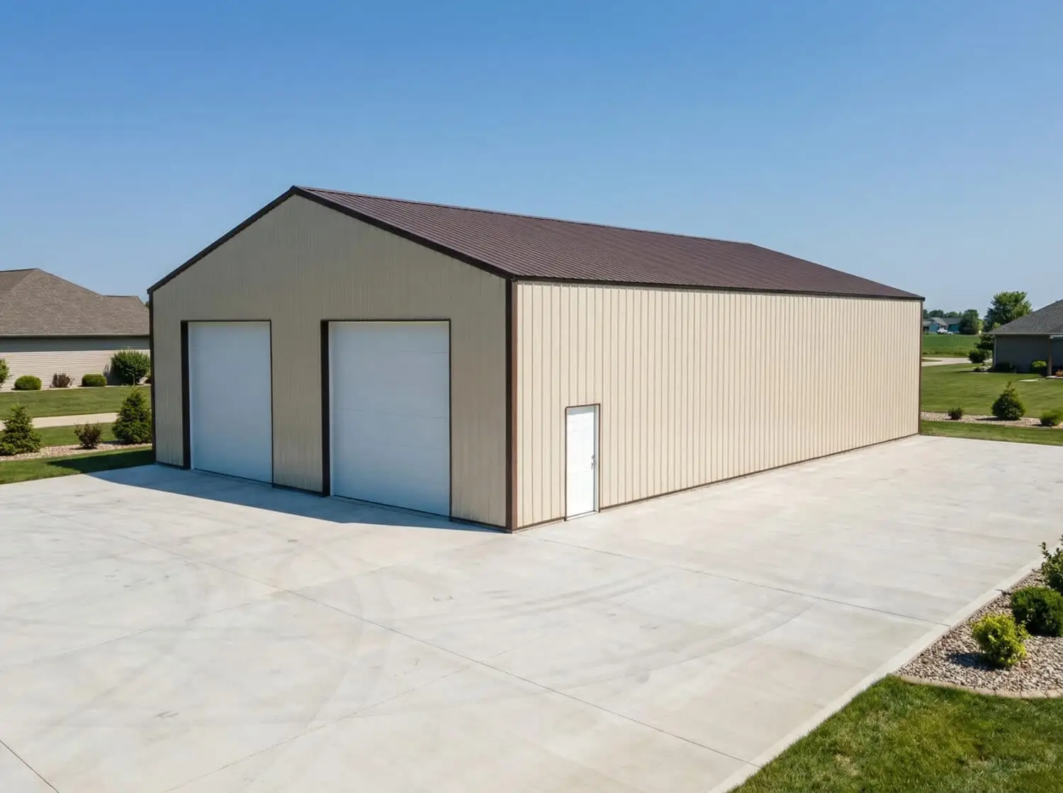 Simulated reference image of a large metal hobby building with two overhead garage doors, a side entry door, a brown metal roof, and a concrete apron in a suburban setting.